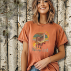 Woman wearing WilderKind deer and forest sunset graphic t-shirt