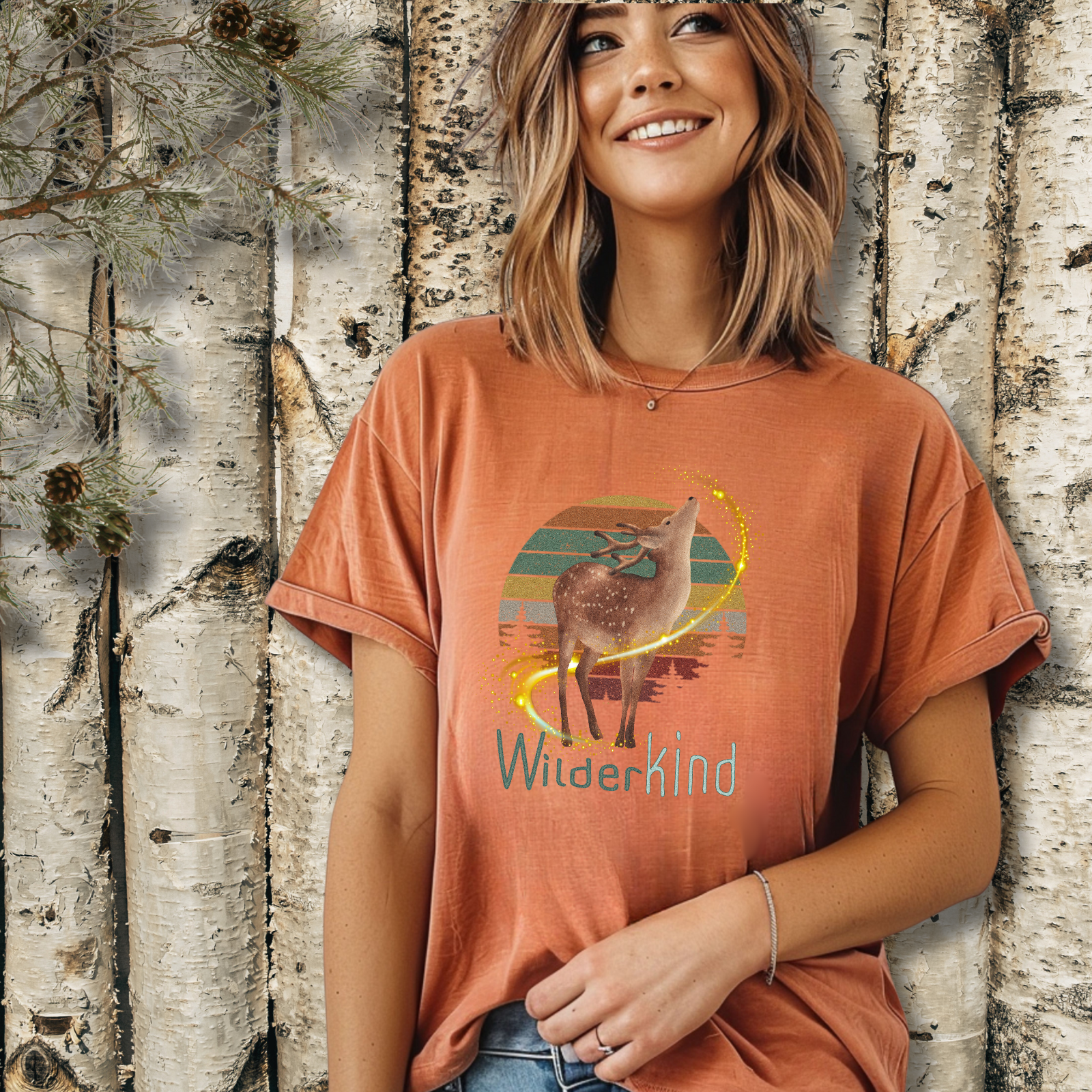 Woman wearing WilderKind deer and forest sunset graphic t-shirt