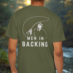 Model wearing olive/green tee showing the large “MEN IN BACKING” back print placement.