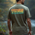 Model wearing green tee showing the bold “STEELHEAD” back graphic in retro sunset tones.