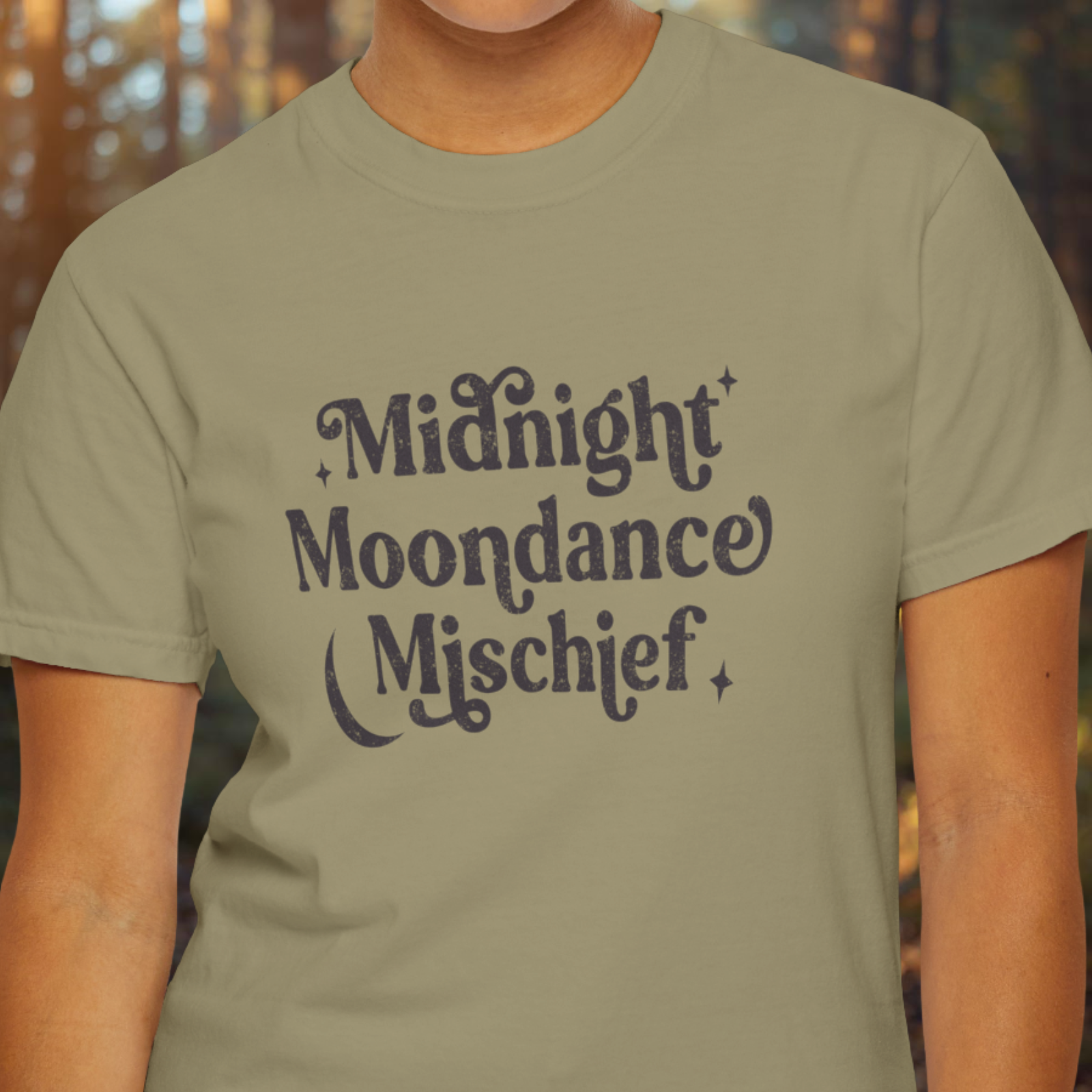 Person wearing a khaki t-shirt with 'Midnight Moondance Mischief' text.