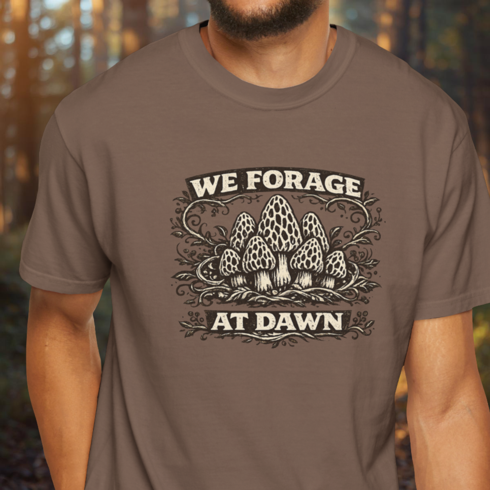 Person wearing a brown t-shirt with 'We Forage at Dawn' graphic design.