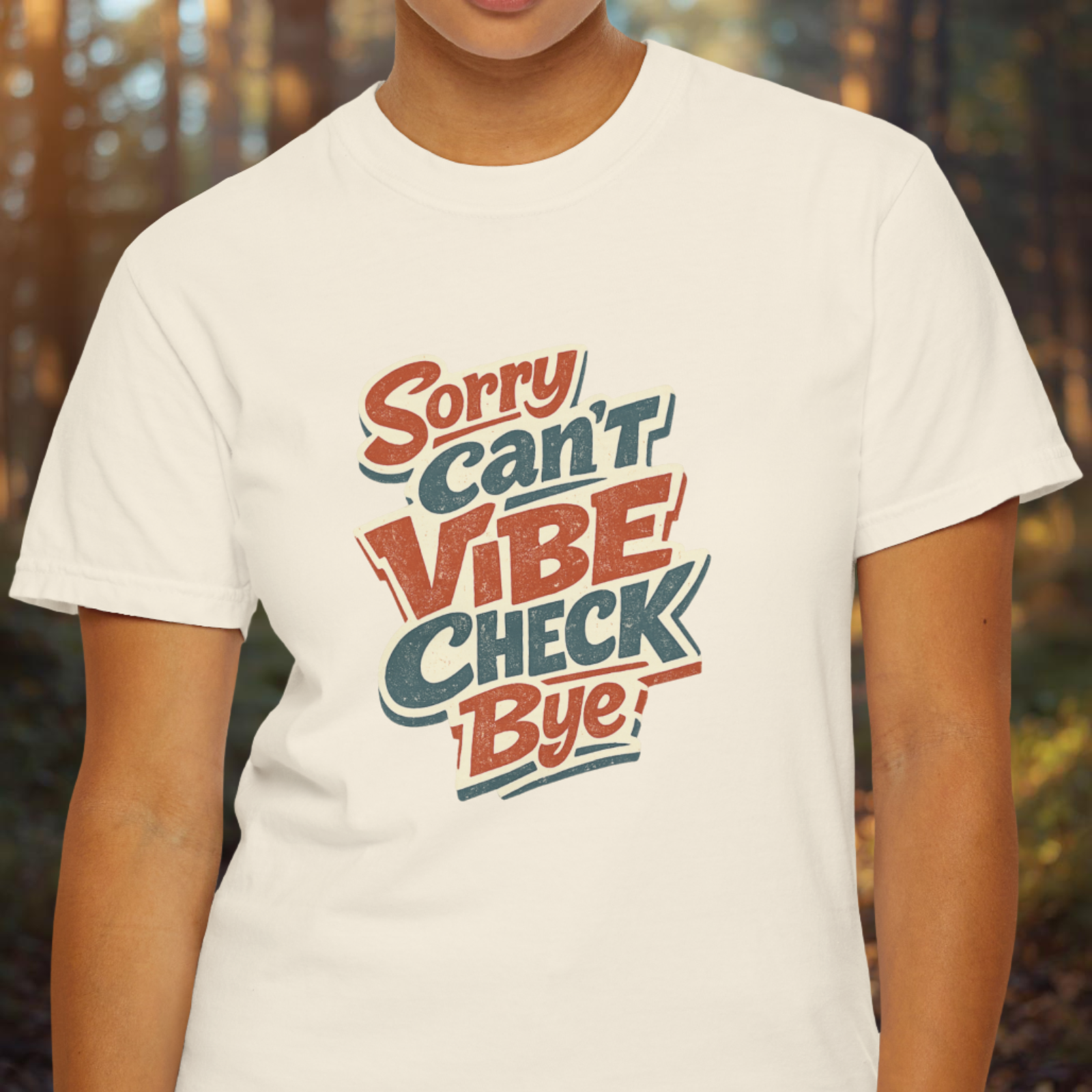 Person wearing a white t-shirt with colorful text design "Sorry Can't Vibe Check Bye" in an outdoor setting