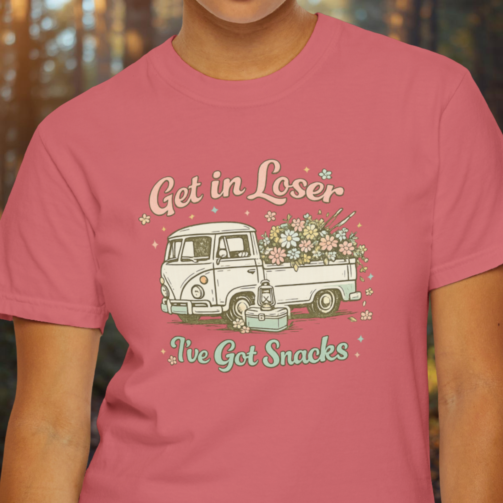 Person wearing a watermelon pink t-shirt with a graphic design and text.