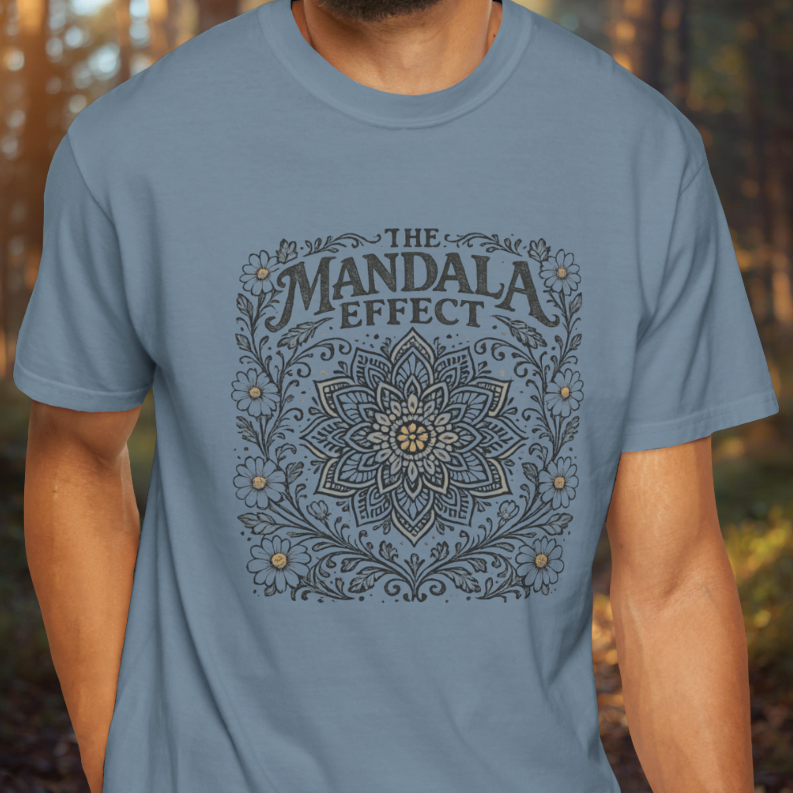 Person wearing a blue t-shirt with 'The Mandala Effect' design.