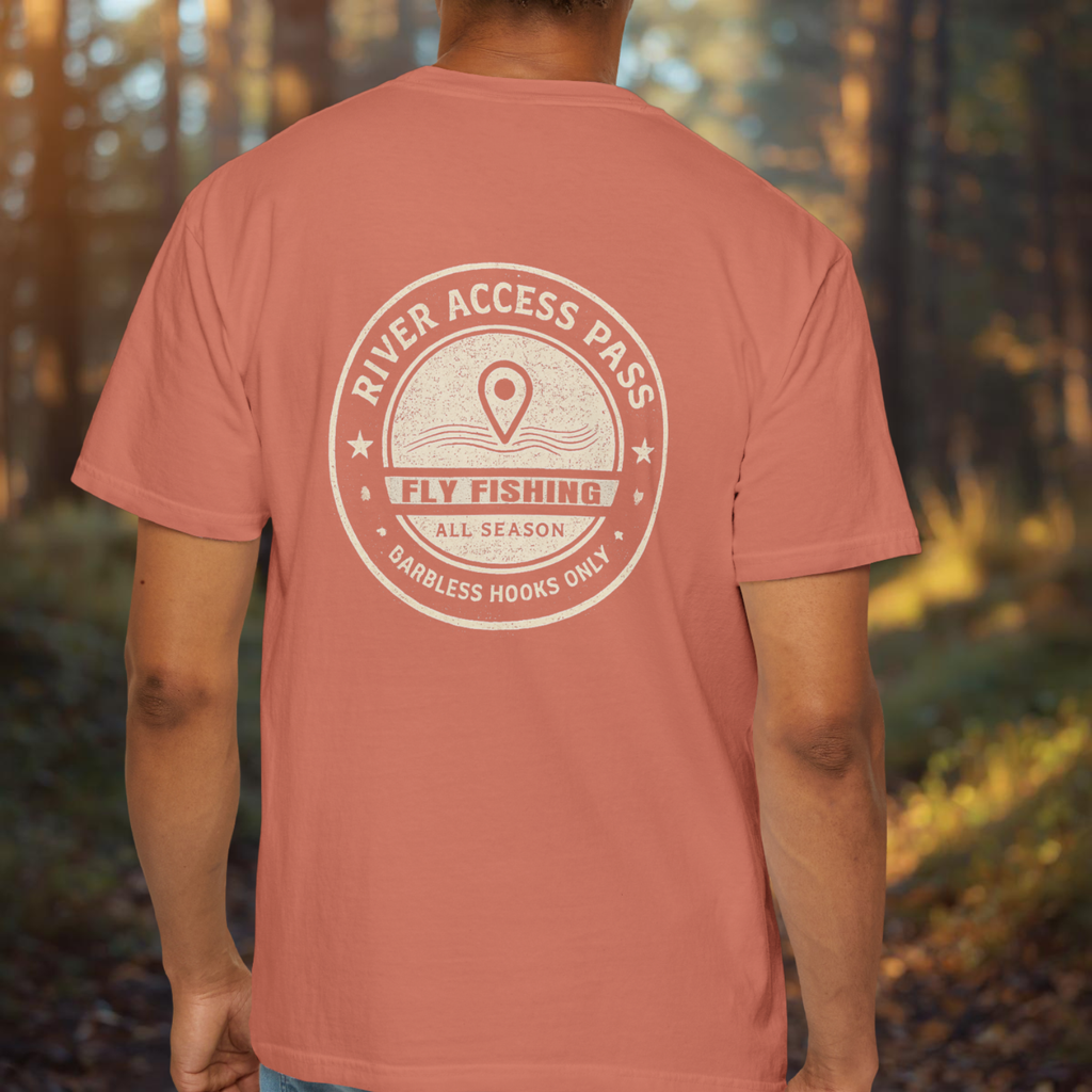 Person wearing a terra cotta t-shirt with a back print River Access Pass circular fishing emblem old map style in a forest setting