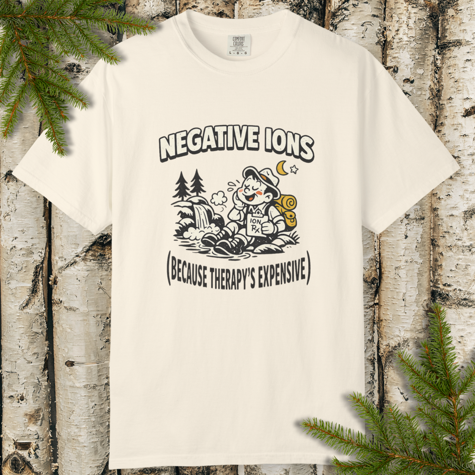 Negative Ions (Because Therapy’s Expensive) graphic t-shirt flat lay with camping cartoon design.