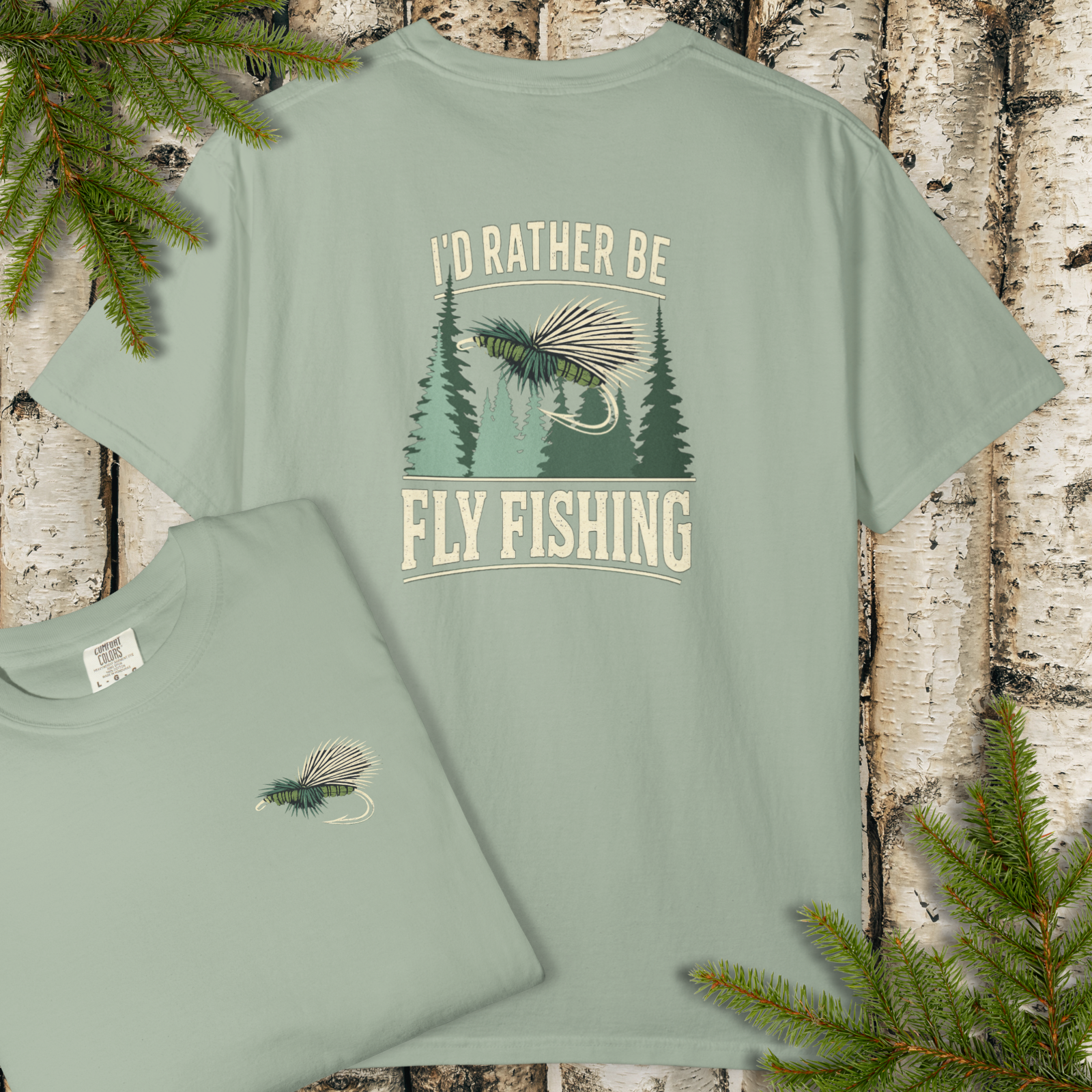 Sage green garment-dyed t-shirt with “I’d Rather Be Fly Fishing” vintage woodland graphic on the back.