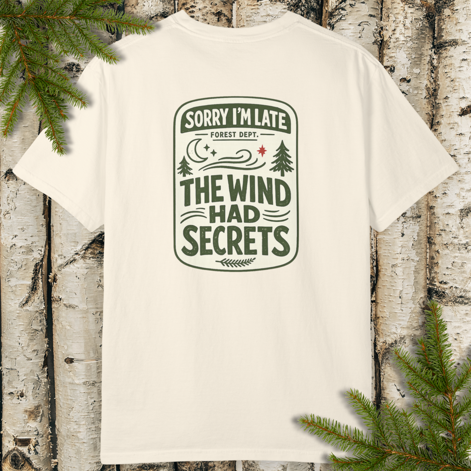 White unisex garment-dyed t-shirt with ‘Sorry I’m Late The Wind Had Secrets’ forest dept sign graphic.