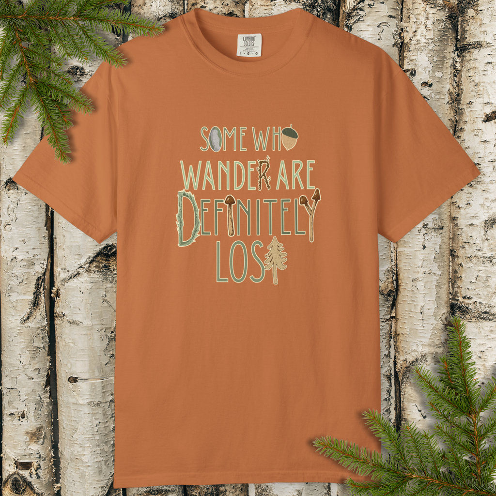 Brown/rust garment-dyed t-shirt with “Some Who Wander Are Definitely Lost” hand-lettered graphic on the front.