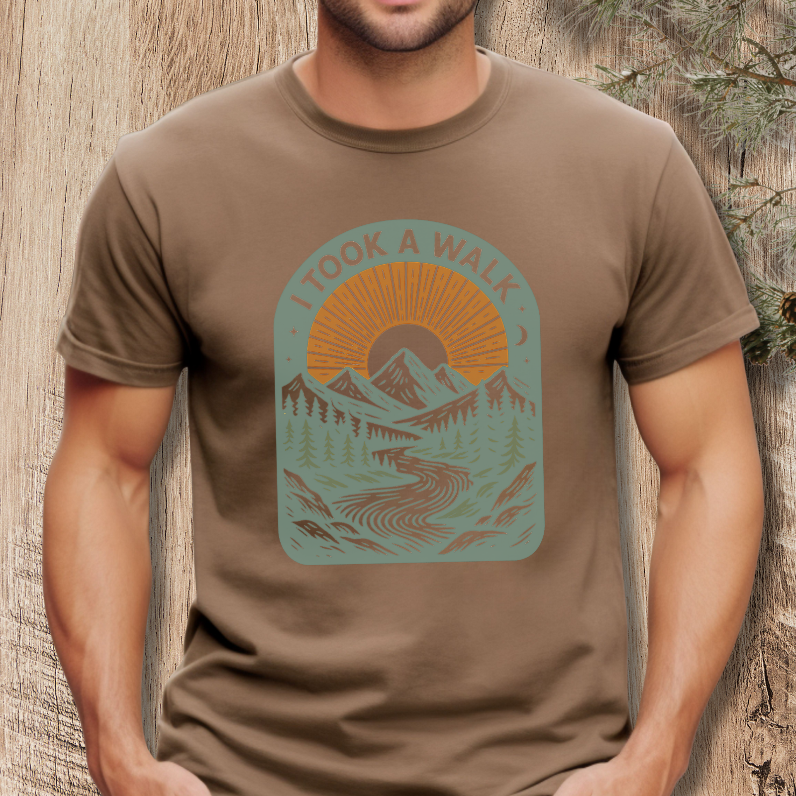 Person wearing a brown t-shirt with a graphic design and text 'I took a walk' against a wooden background.