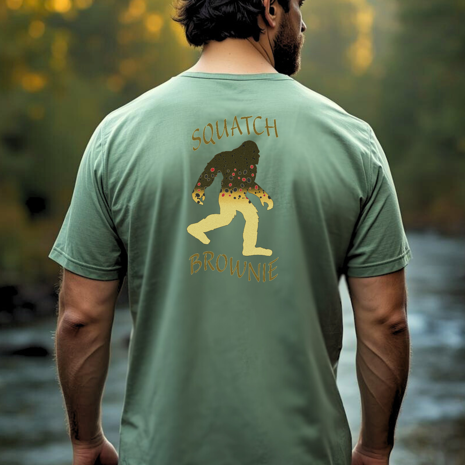 Person wearing Squatch Brownie brown trout Bigfoot tee outdoors