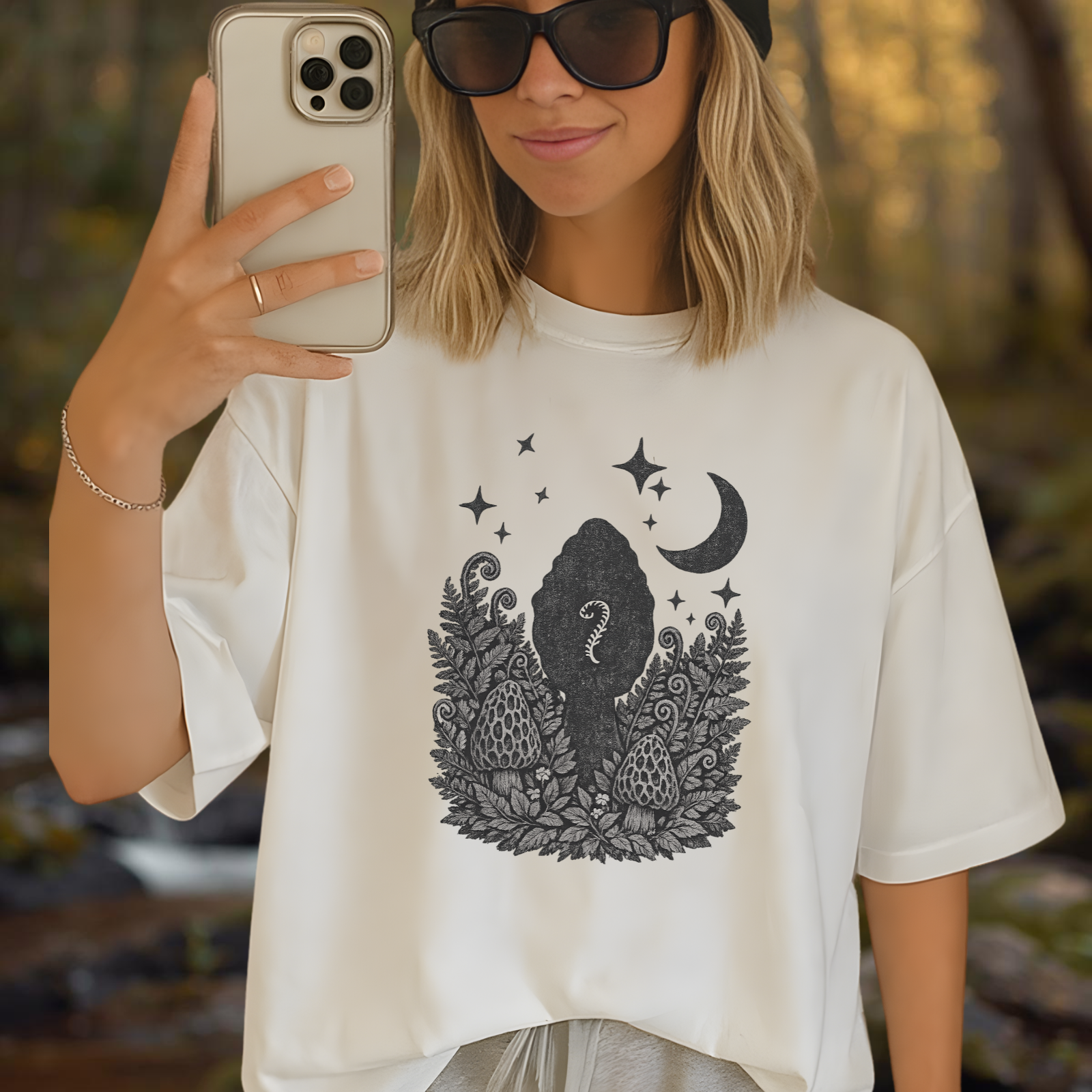 Lifestyle photo of person wearing a light-colored tee with the moon and fern curl graphic centered on the chest.