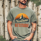 Person wearing a terracotta “Northern Attitude” mountain sunset graphic tee in a casual outdoor setting.