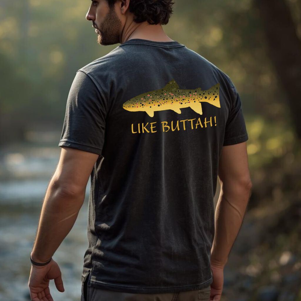Angler wearing ‘Like Buttah’ brown trout graphic tee by the river