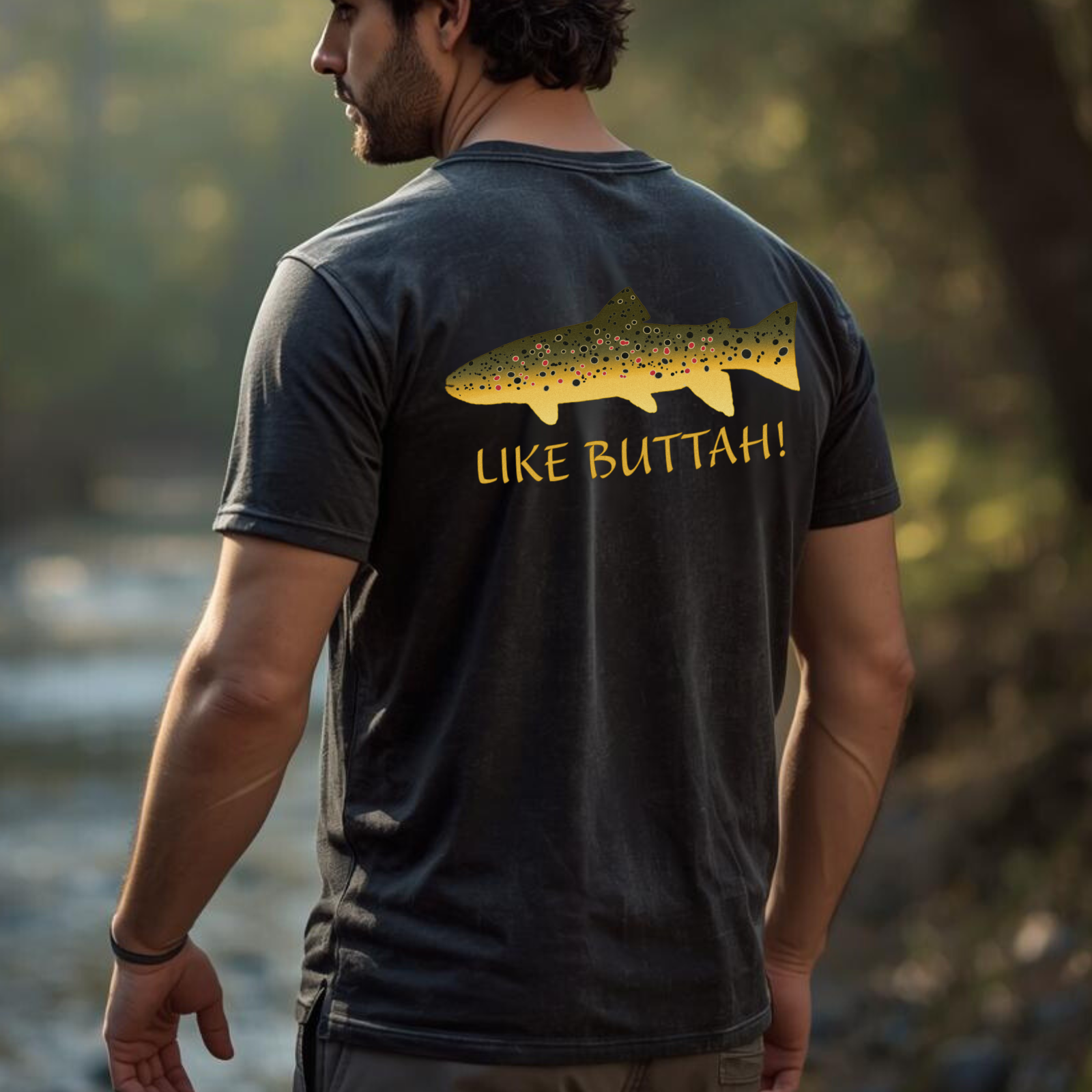 Angler wearing ‘Like Buttah’ brown trout graphic tee by the river