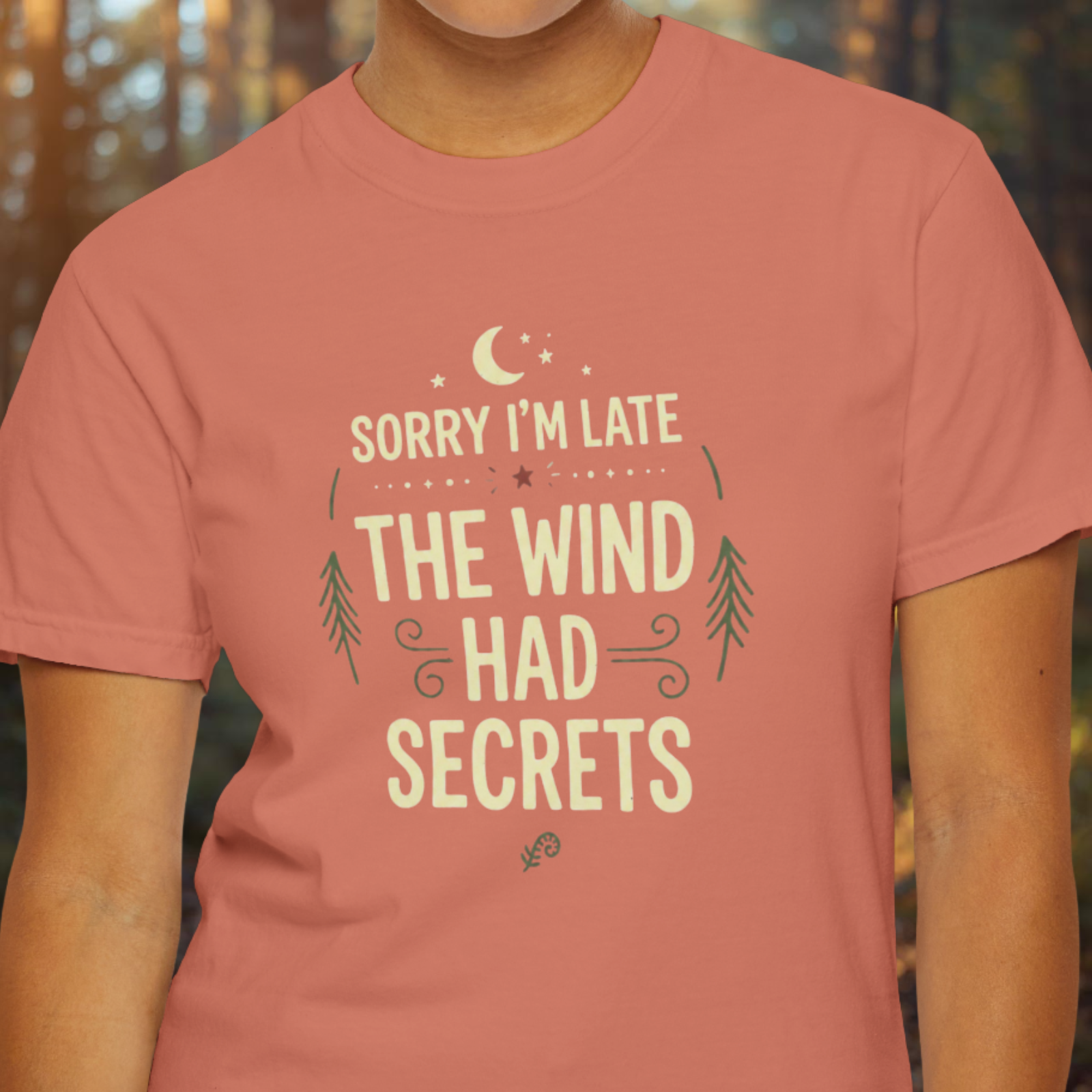 Model wearing Sorry I’m Late The Wind Had Secrets shirt with minimalist line art moon graphic.
