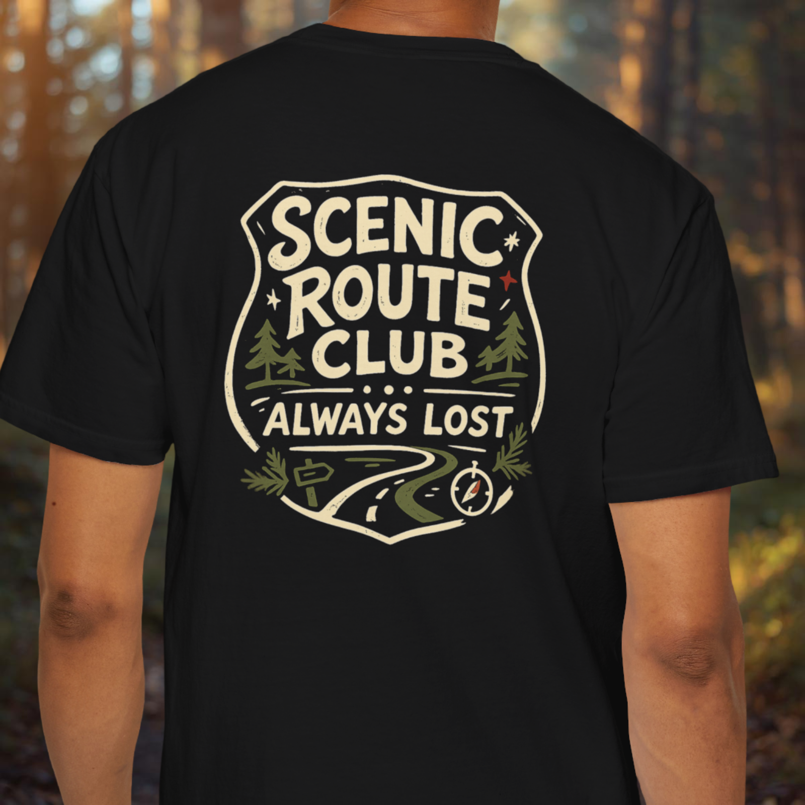 Black t-shirt with 'Scenic Route Club Always Lost' design on the back, worn by a person in a forest setting.