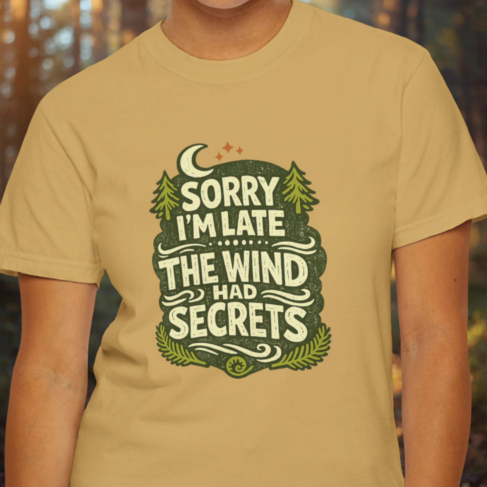Model wearing mustard t-shirt with “Sorry I’m Late The Wind Had Secrets” vintage forest patch design.