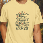 Person wearing a yellow t-shirt with a funny camping graphic reading “Trail Mixed Opinions Mostly Salty” in a vintage outdoor design