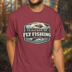 Person wearing a maroon t-shirt with 'I'd Rather Be Fly Fishing' graphic design.