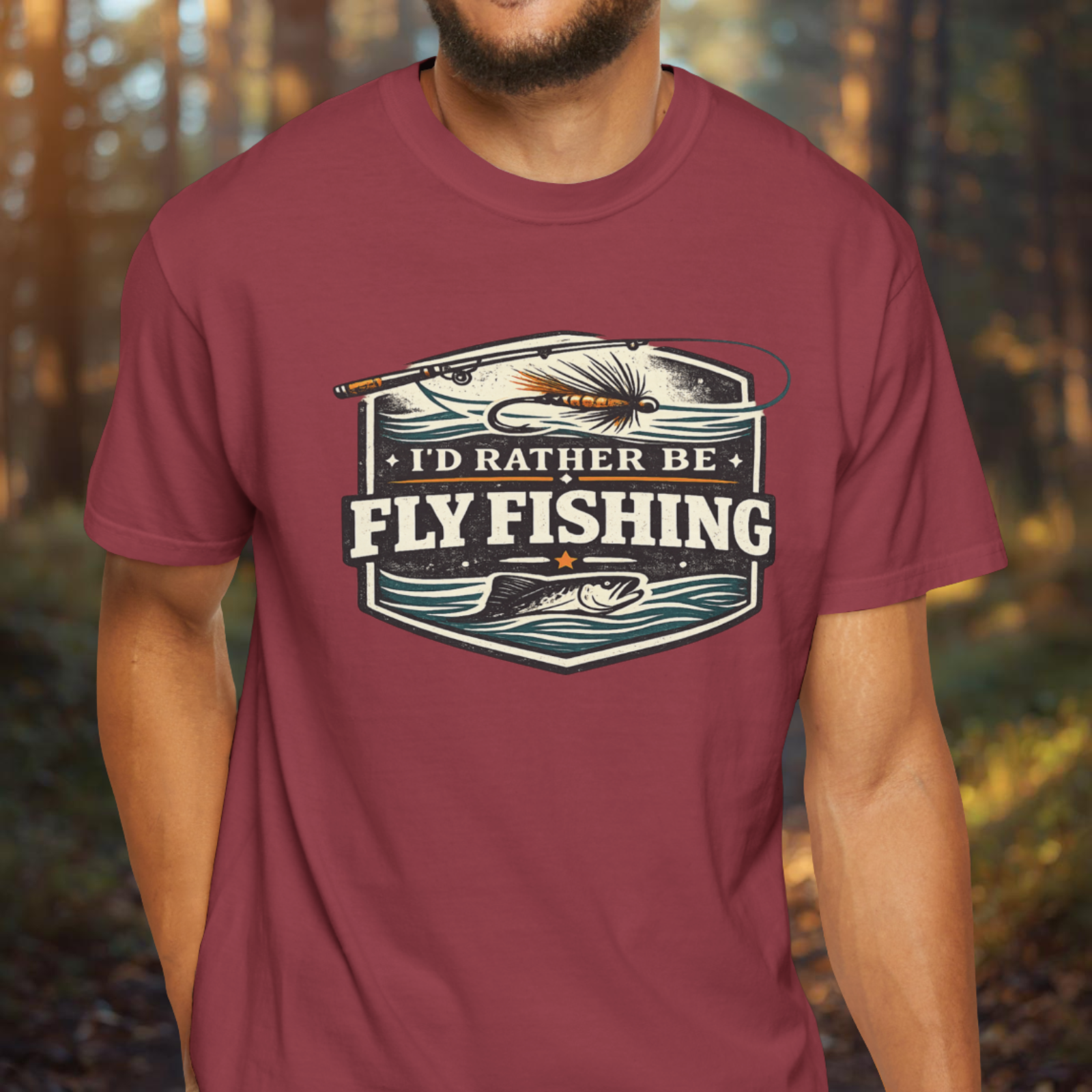 Person wearing a maroon t-shirt with 'I'd Rather Be Fly Fishing' graphic design.