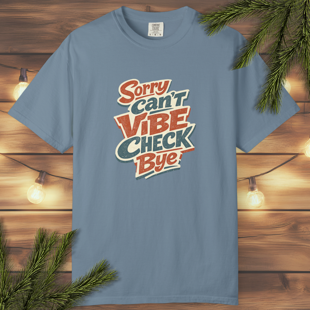 Retro “Sorry Can’t Vibe Check Bye” graphic tee with layered vintage lettering in cream, rust, and teal on a garment-dyed shirt.