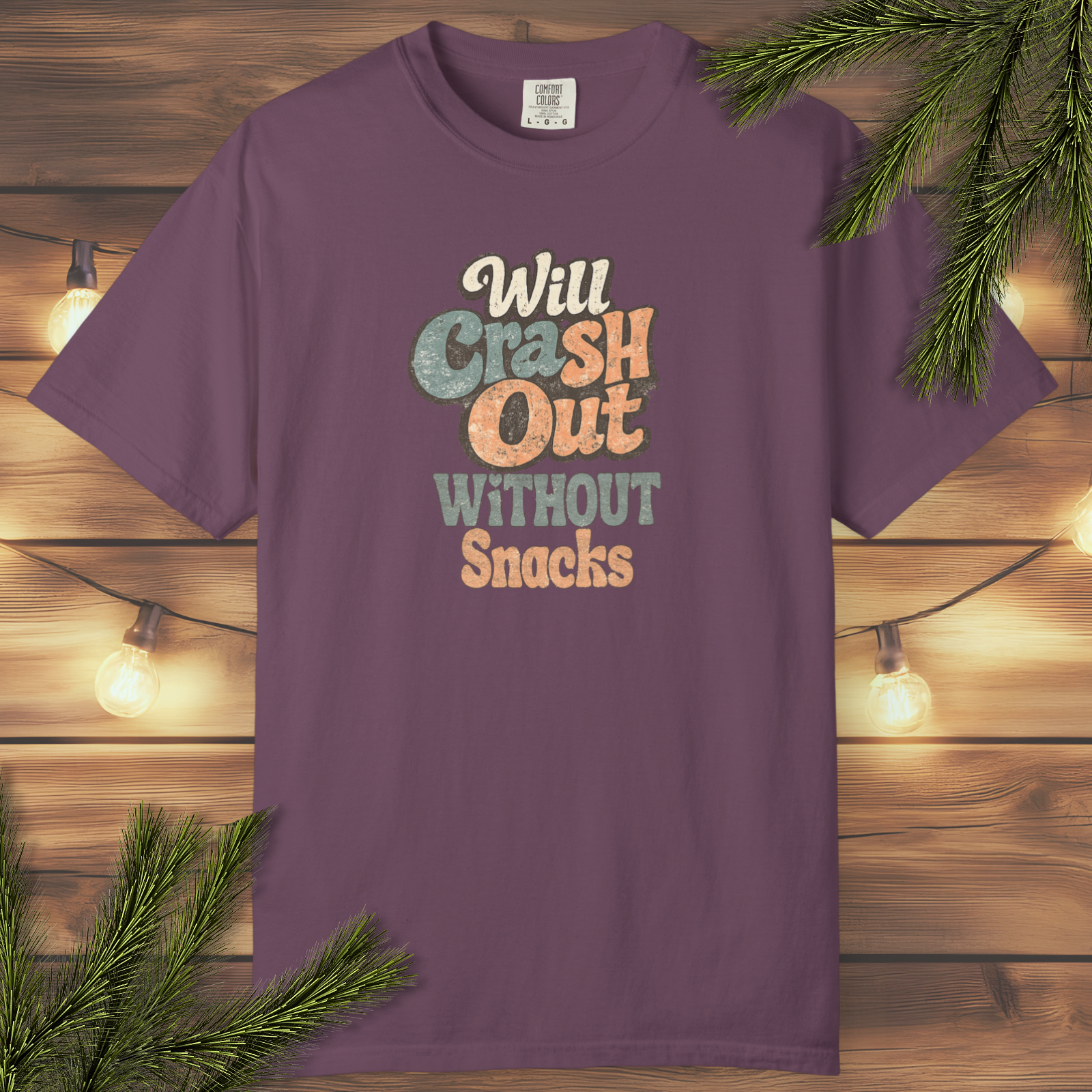 Retro graphic t-shirt with the phrase “Will Crash Out Without Snacks” in playful vintage lettering on a garment-dyed tee.