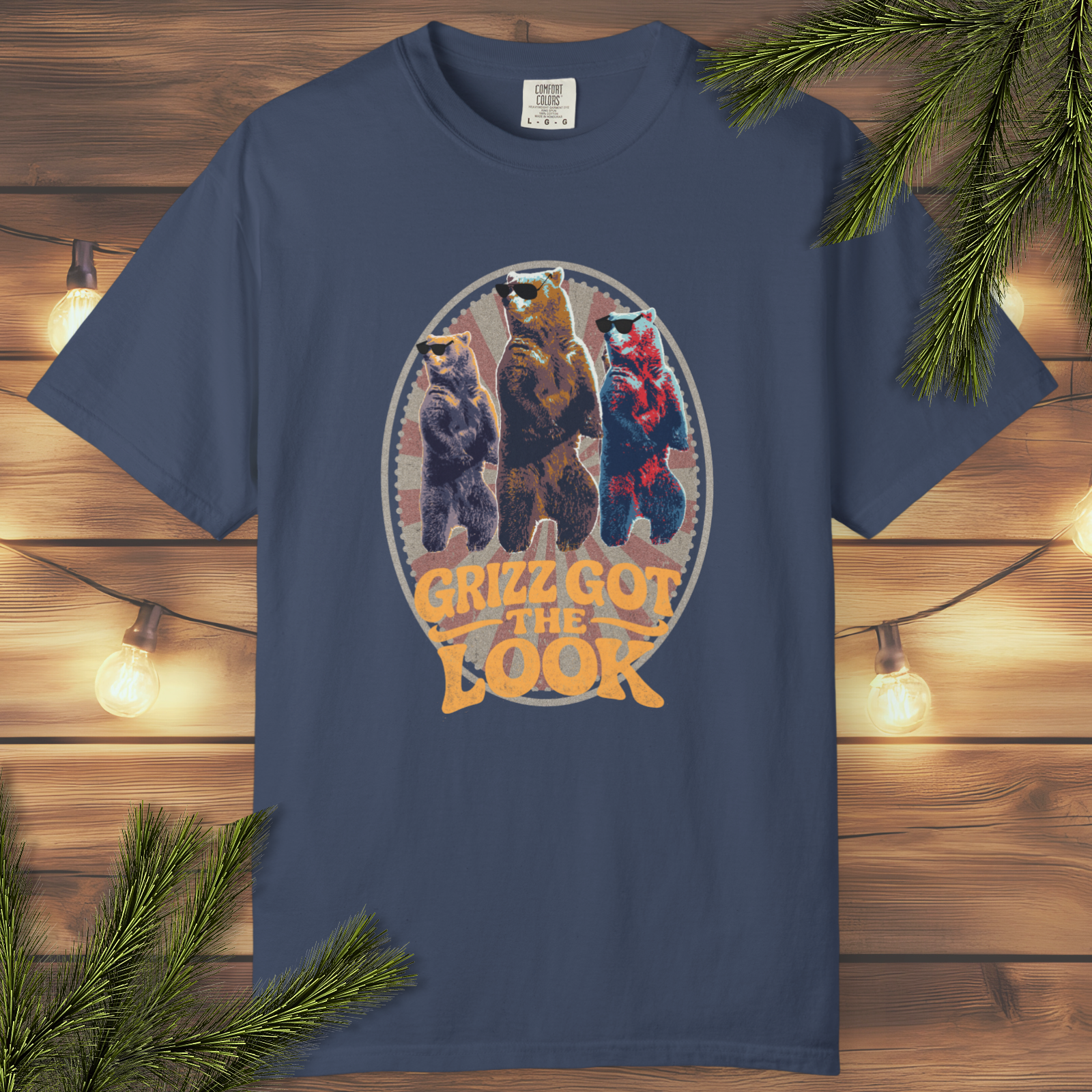 Navy blue t-shirt with bear trio graphic and 'Grizz Got the Look' text on a wooden background.