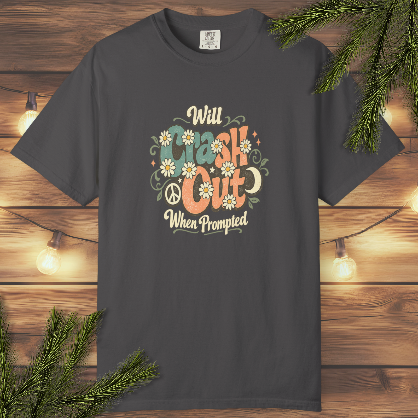 Retro floral “Will Crash Out When Prompted” graphic t-shirt with vintage-style lettering and soft 70s-inspired flower details on a garment-dyed tee