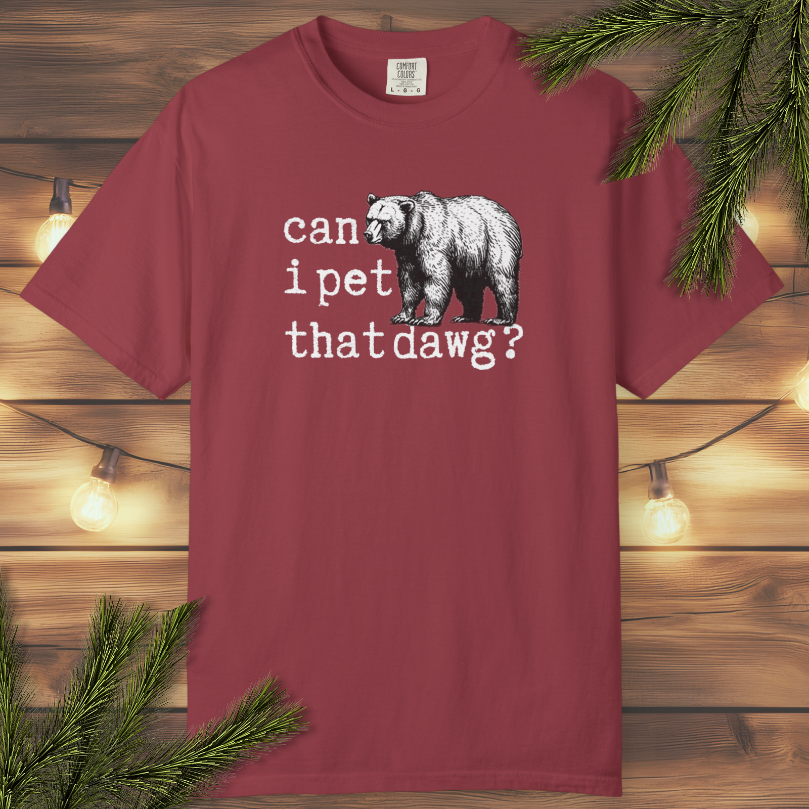 Maroon t-shirt with bear graphic and text on a wooden background